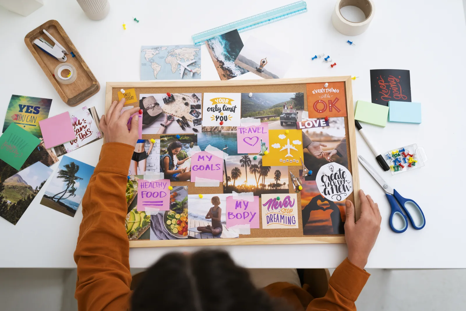 Hands bringing ideas and visual references together on a moodboard
